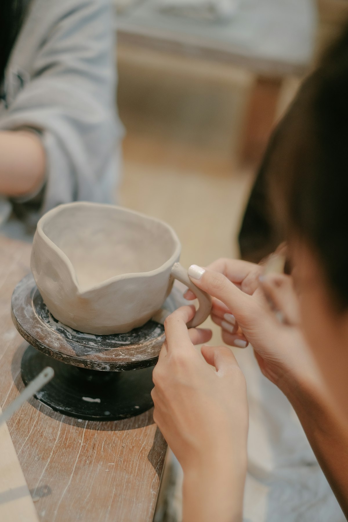 Hands shaping clay in a workshop